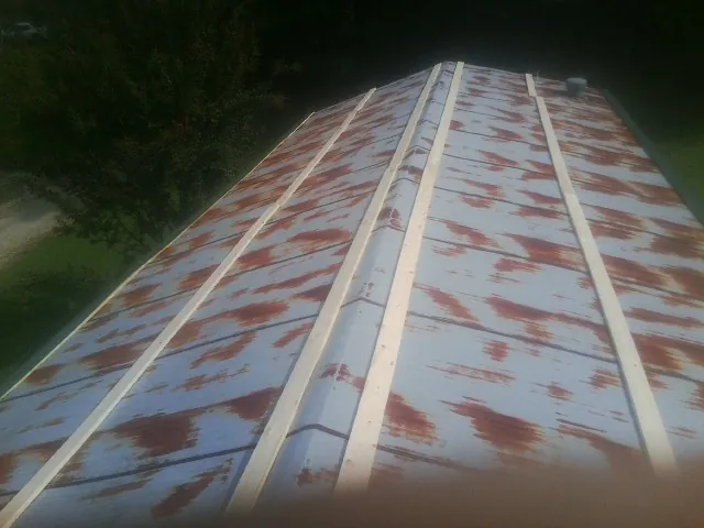 Rusted metal roof panels with new wood purlins before replacement — Storm Damage Roof Repair in Felicity by Roofing Brothers